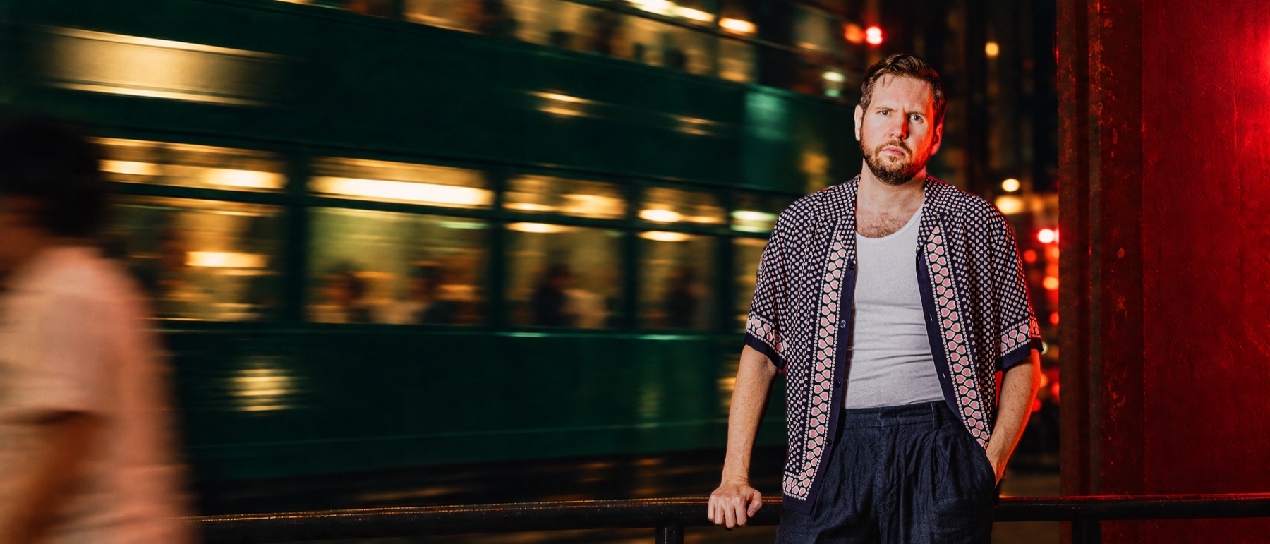 Sonny Zamolo in a city street at night, red light against a blurred background.